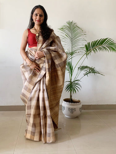 Handloom fletcher Silk Saree .The grey saree has check details on it and comes with a matching blouse piece. 