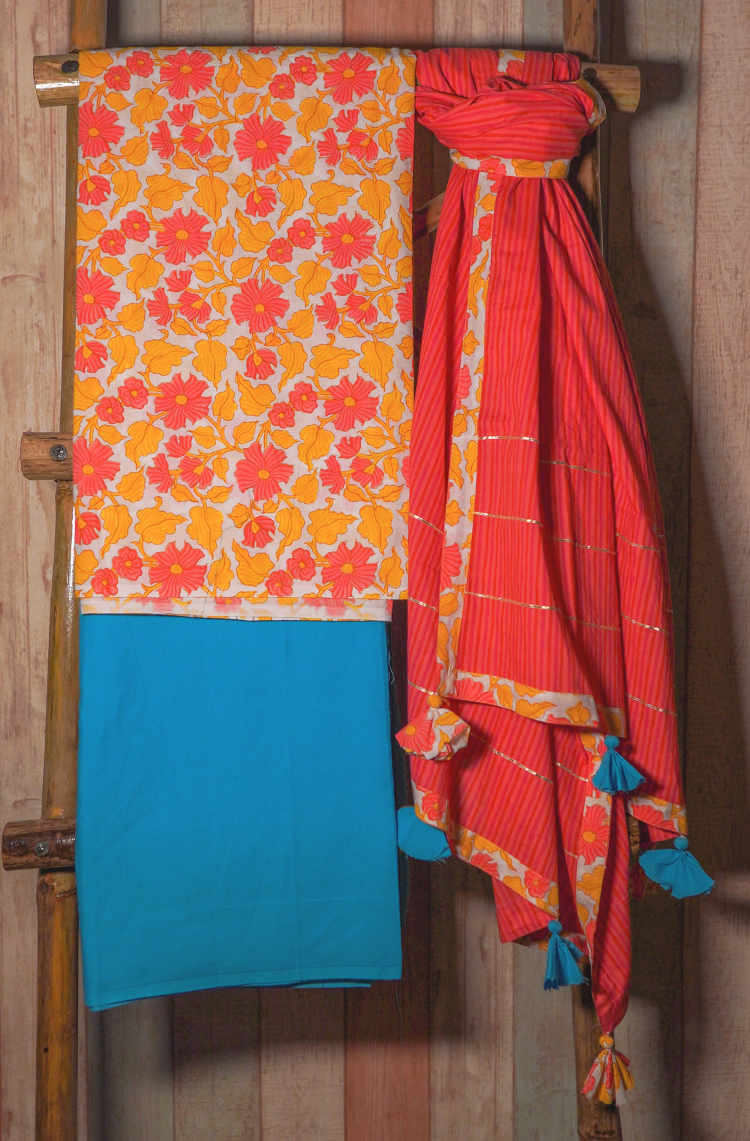 Handblock printed cotton floral kurta with blue bottom and orange dupatta with tassels. 