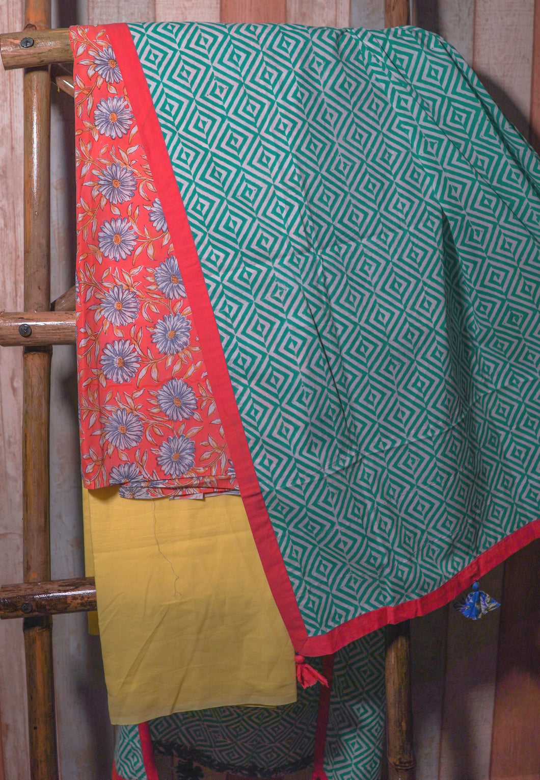 Orange floral kurta is paired with solid yellow bottom and green geometric printed dupatta